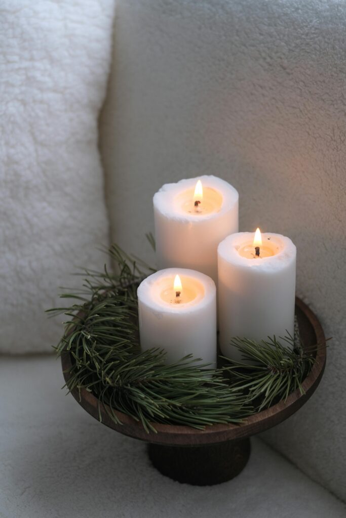 Three softly glowing pillar candles representing the three core pillars of intuitive marketing: authenticity, connection, and trust.